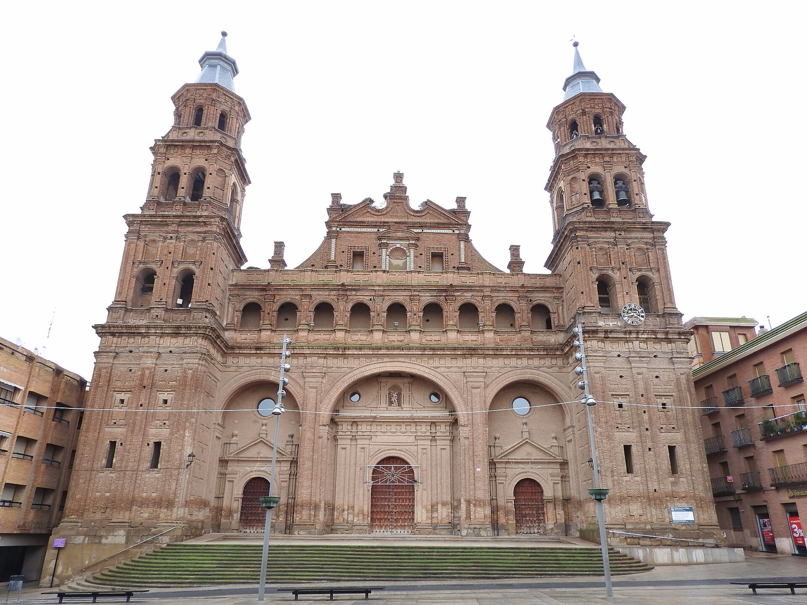 Fachada de la Colegiata de San Miguel Arcángel en Alfaro, La Rioja, con edificios de viviendas a ambos lados