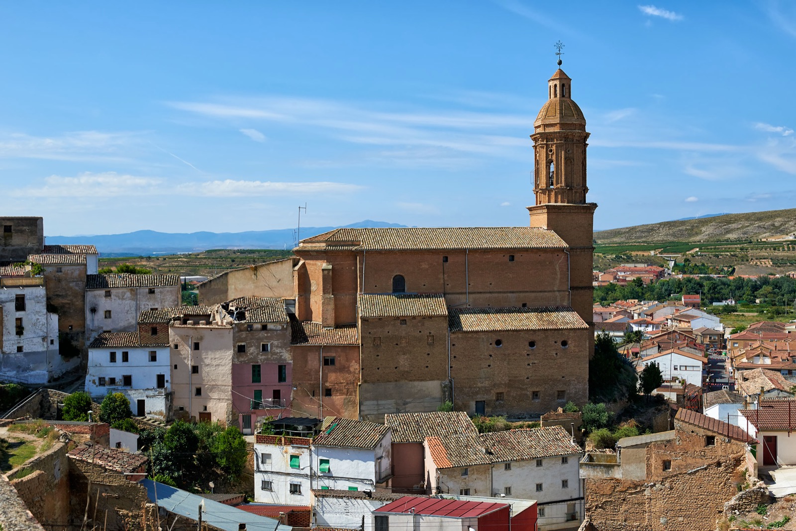 Vista de Andosilla, en la Ribera de Navarra, con la iglesia parroquial y su torre sobre los tejados del casco urbano y la huerta al fondo