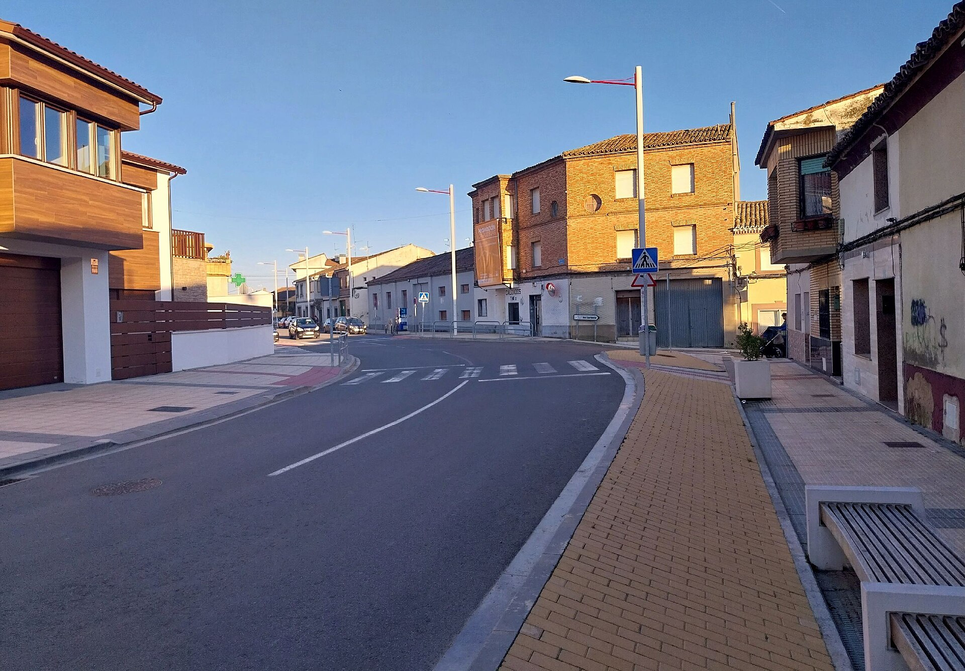Calle de Cadreita, en la Ribera de Navarra, con una vivienda unifamiliar nueva a la izquierda y casas tradicionales de ladrillo a la derecha