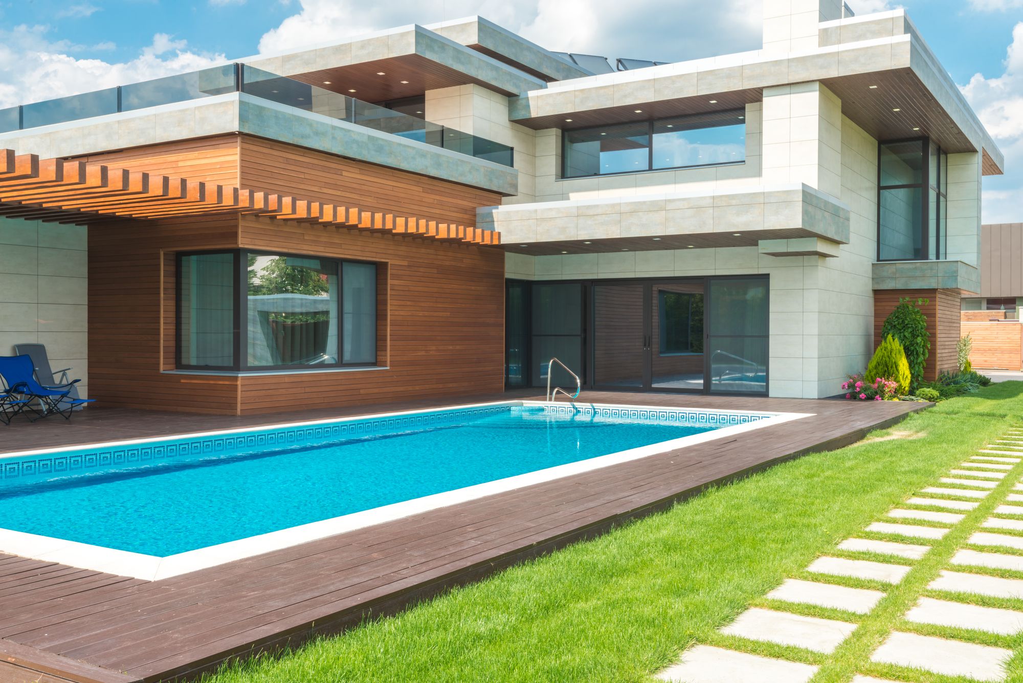 Casa unifamiliar moderna con piscina privada, tarima de madera y jardín de césped