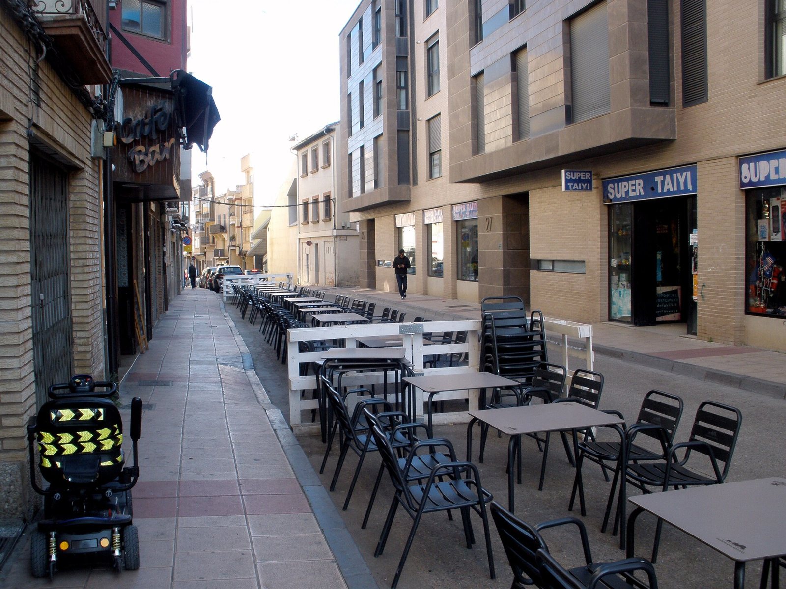 Calle de Cintruénigo con bloques de viviendas de ladrillo, comercios en planta baja y terrazas de bar en la acera
